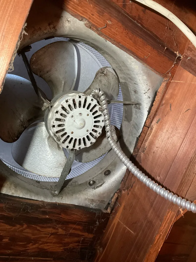 Old whole-house attic fan motor with worn wiring before replacement