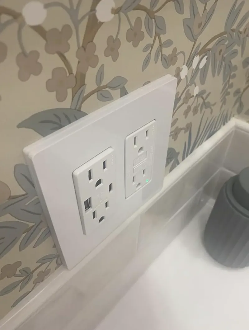 Installed USB-A/C outlet and GFCI outlet at bathroom vanity, angled view