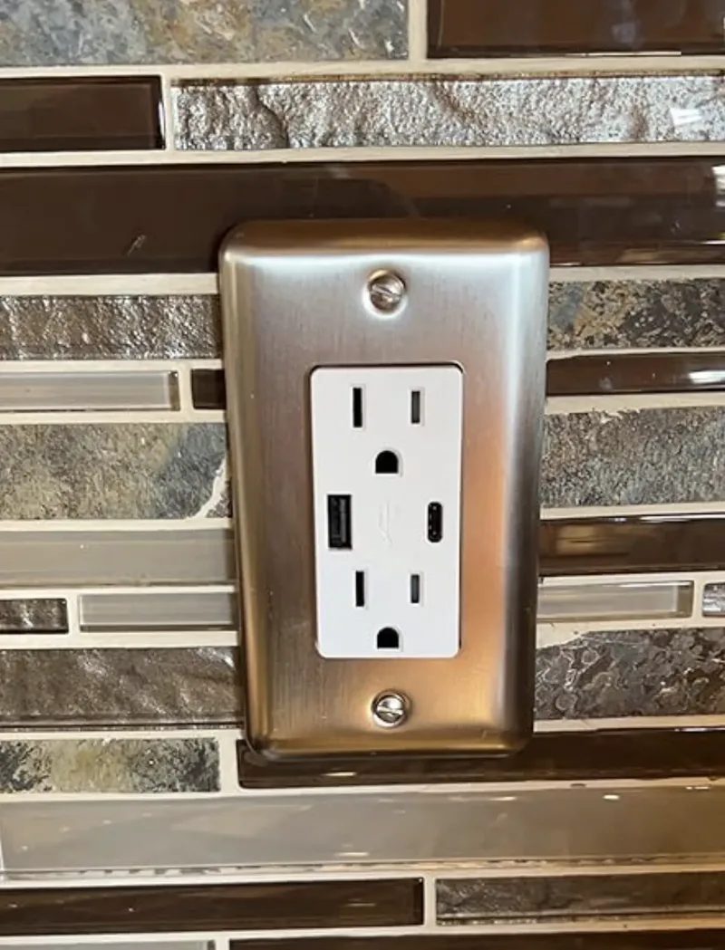 USB-A and USB-C outlet installed on kitchen tile backsplash with brushed nickel plate
